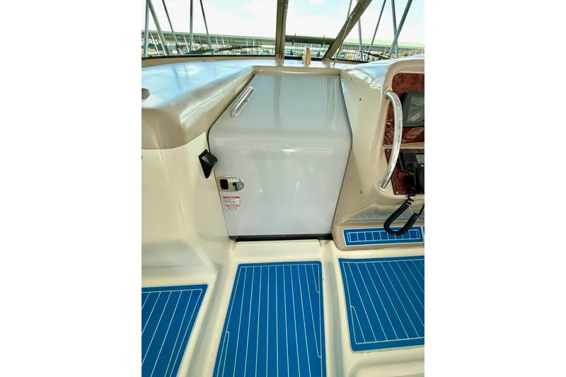 Slide: The Image of 2005 Sea Ray 340 Sundancer cockpit with blue flooring and control panel. - 19