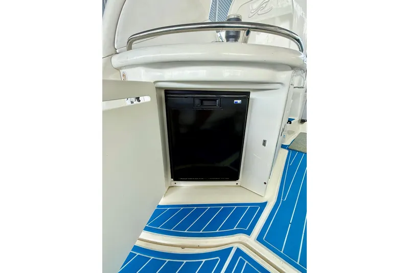 Slide: The Image of 2005 Sea Ray 340 Sundancer interior with open cabinet and blue flooring. - 20