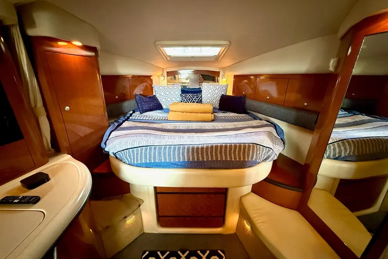 Slide: The Image of Luxurious cabin interior of 2005 Sea Ray 340 Sundancer with cozy bedding and elegant wood finishes. - 23
