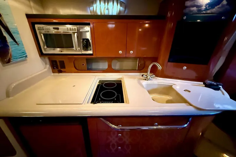 Slide: The Image of 2005 Sea Ray 340 Sundancer kitchen with microwave, stove, and sink. - 29