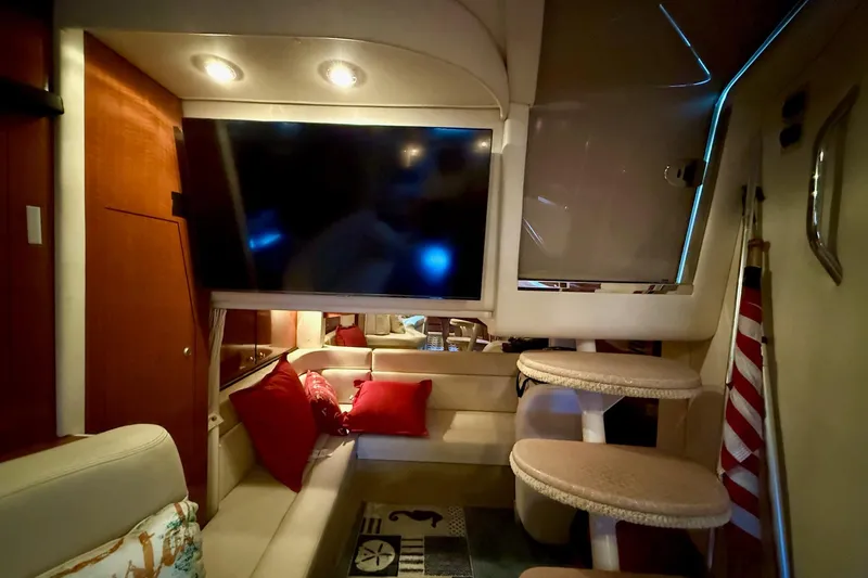 Slide: The Image of Interior of 2005 Sea Ray 340 Sundancer with cozy seating, TV, and nautical decor. - 30