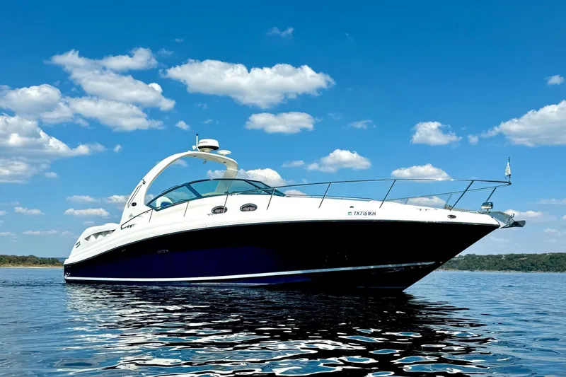 Slide: The Image of 2005 Sea Ray 340 Sundancer yacht on calm water under a clear blue sky. - 6