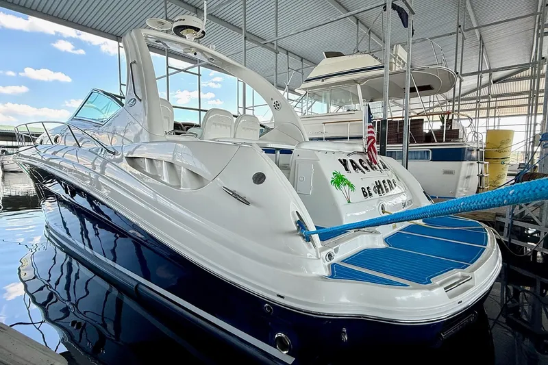 Slide: The Image of 2005 Sea Ray 340 Sundancer yacht docked in a marina under a metal roof. - 8
