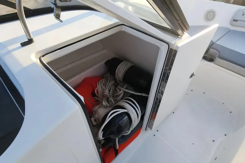 Slide: The Image of 2022 Bayliner VR6 Bowrider OB storage compartment with ropes and fenders. - 12