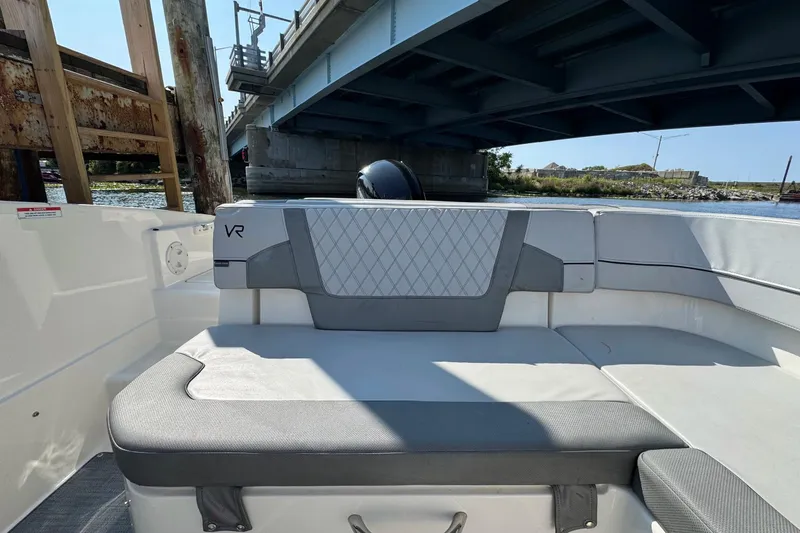 Slide: The Image of 2022 Bayliner VR6 Bowrider OB interior under a bridge, showcasing seating and design. - 13