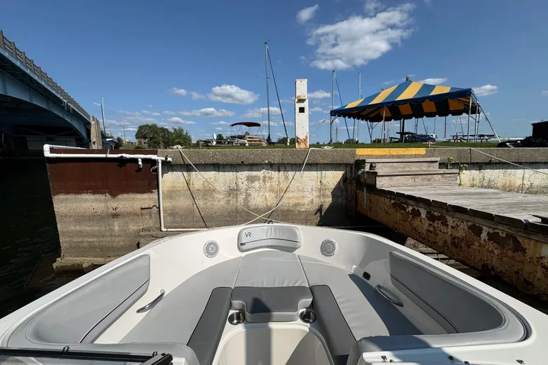 Slide: The Image of 2022 Bayliner VR6 Bowrider OB docked near a bridge under a blue sky. - 7