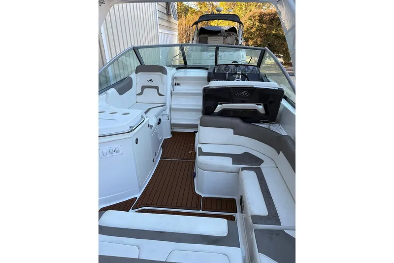 Slide: The Image of 2016 Monterey 275 Sport Yacht interior with white and gray seating, wood flooring, and helm. - 5