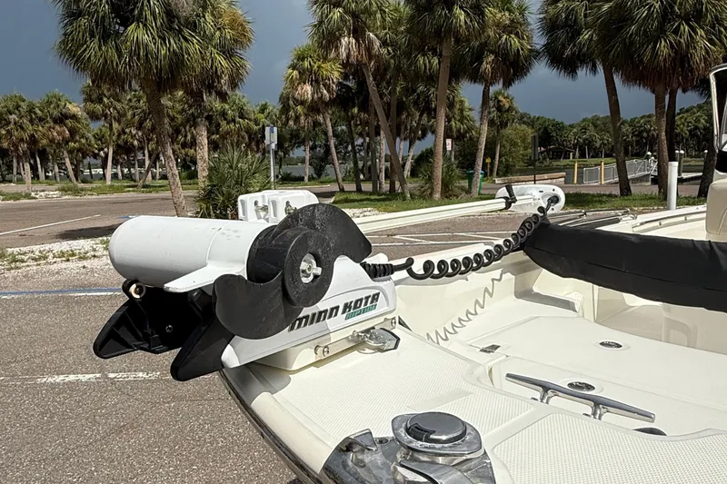 Slide: The Image of 2021 Boston Whaler 170 Montauk with Minn Kota motor, parked near palm trees. - 11