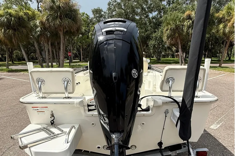 Slide: The Image of 2021 Boston Whaler 170 Montauk boat with outboard motor, parked near palm trees. - 16