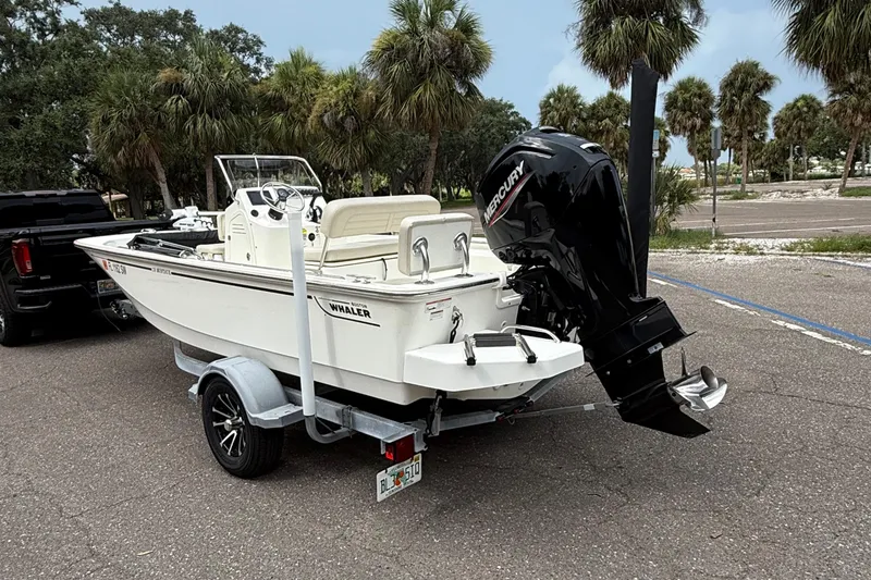 Slide: The Image of 2021 Boston Whaler 170 Montauk boat on trailer, parked near palm trees. - 3