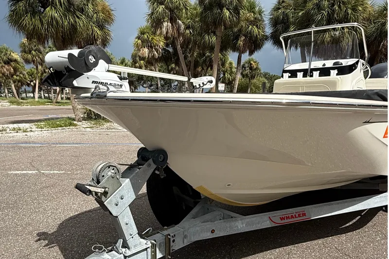 Slide: The Image of 2021 Boston Whaler 170 Montauk boat on trailer, parked near palm trees. - 8