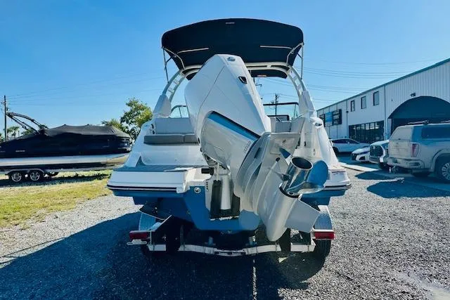 Slide: The Image of 2026 Sea Ray SPX 230 Outboard boat, rear view with powerful engine, parked outdoors. - 2