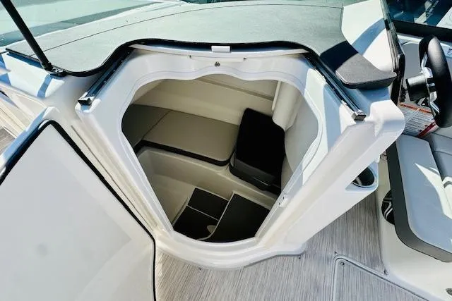 Slide: The Image of 2026 Sea Ray SPX 230 Outboard boat interior cabin with seating and storage. - 22
