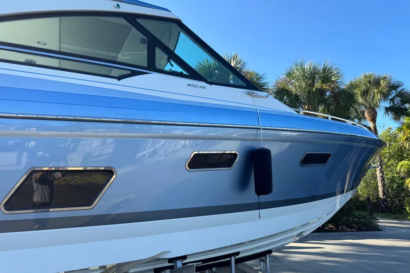 Slide: The Image of 2023 Formula 400 Super Sport Crossover boat with sleek design, docked under clear blue sky. - 27