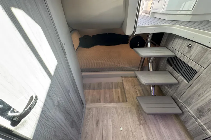 Slide: The Image of 2023 Formula 400 Super Sport Crossover cabin interior with modern wood finish and compact stairs. - 77