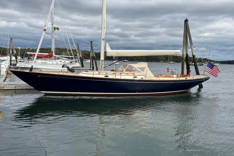 The Image of 2015 Hinckley DS 42 sailboat docked, featuring sleek design and American flag. - 0