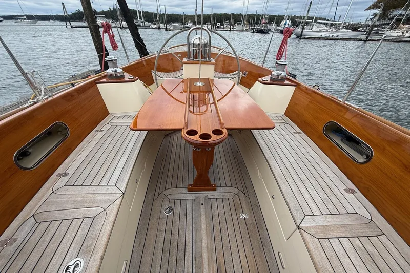 Slide: The Image of Hinckley DS 42 sailboat cockpit, 2015 model, featuring wooden accents and marina backdrop. - 14