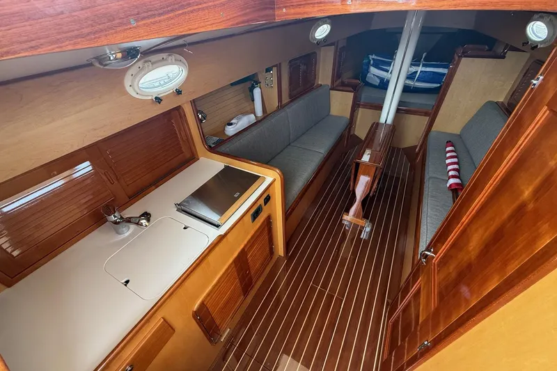 Slide: The Image of Interior of 2015 Hinckley DS 42 sailboat with wooden finishes and compact seating area. - 49