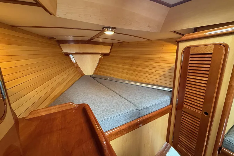 Slide: The Image of Cozy cabin interior of 2015 Hinckley DS 42 with wooden paneling and cushioned bed. - 57