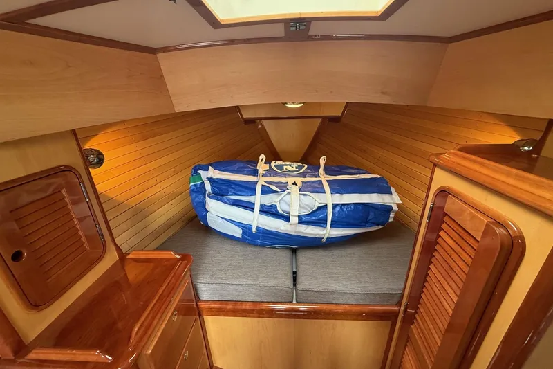 Slide: The Image of Hinckley DS 42 cabin interior, 2015 model, featuring wooden paneling and a neatly stored sail. - 60