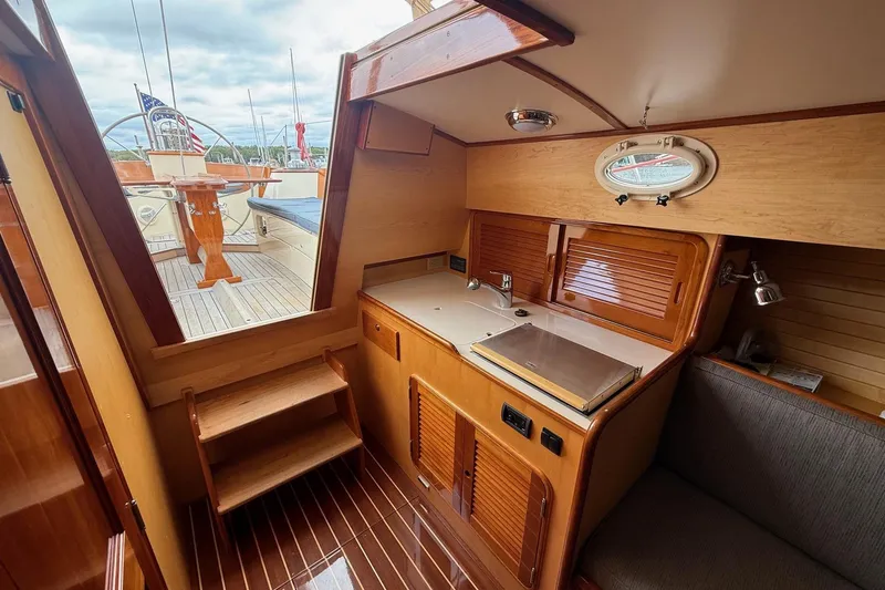Slide: The Image of Interior of 2015 Hinckley DS 42 yacht with wooden cabinetry and compact kitchen area. - 62