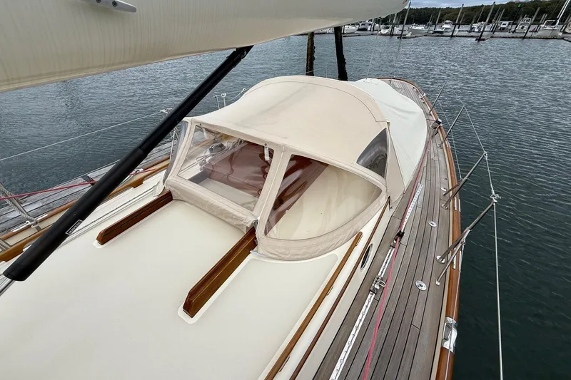 Slide: The Image of Hinckley DS 42 sailboat, 2015 model, docked with beige canopy and wooden deck. - 18