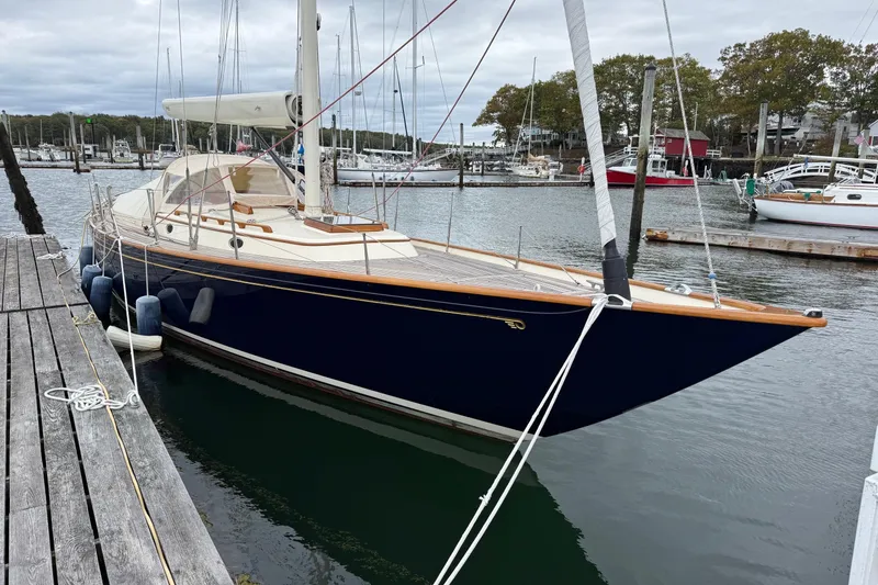 Slide: The Image of 2015 Hinckley DS 42 sailboat docked in a marina, featuring sleek design and classic elegance. - 2