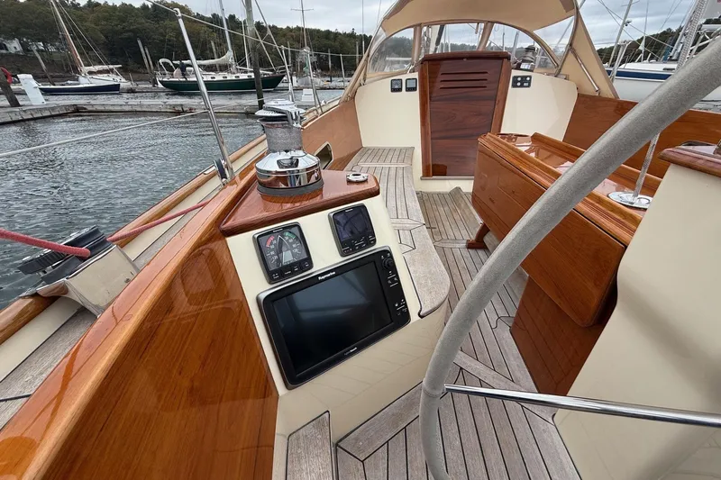 Slide: The Image of Hinckley DS 42 sailboat cockpit with navigation instruments, wooden finish, and marina view. - 37