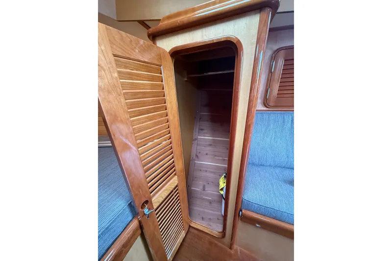 Slide: The Image of Interior of 2015 Hinckley DS 42 sailboat with wooden cabinetry and blue seating. - 61