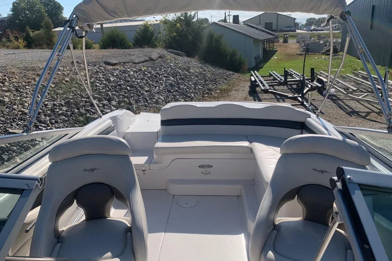 Slide: The Image of 2003 Four Winns 240 Horizon boat interior with seating and canopy, parked outdoors. - 12