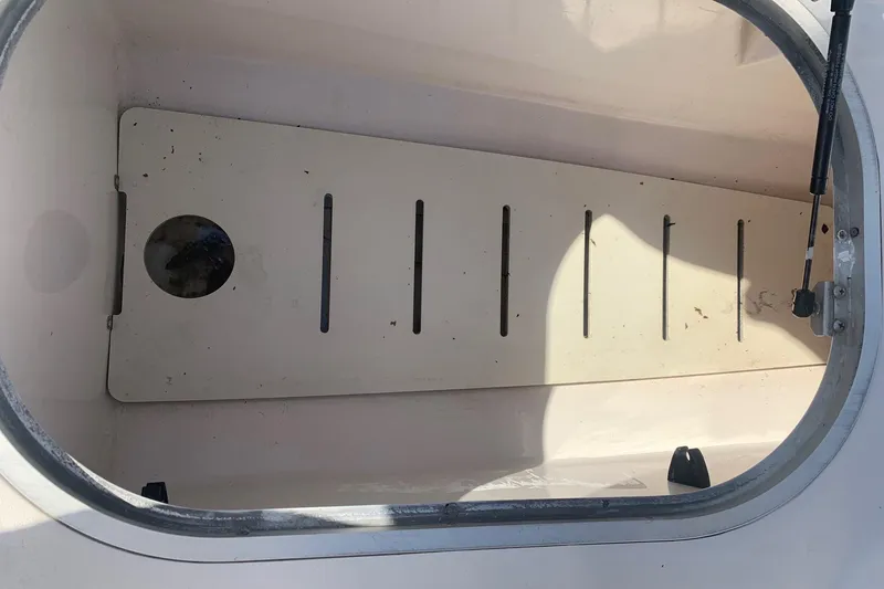 Slide: The Image of Storage compartment of a 2003 Four Winns 240 Horizon boat, featuring a slotted floor. - 19