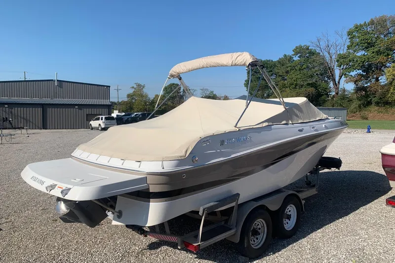 Slide: The Image of 2003 Four Winns 240 Horizon boat on trailer, covered, in outdoor setting. - 2