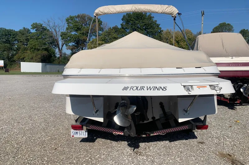 Slide: The Image of 2003 Four Winns 240 Horizon boat with cover, parked on gravel lot. - 3