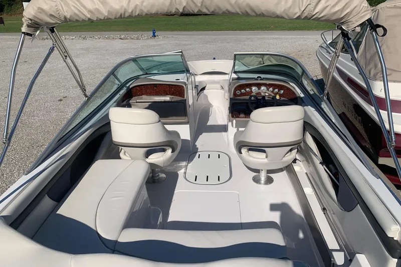 Slide: The Image of 2003 Four Winns 240 Horizon boat interior with white seating and dashboard controls. - 4