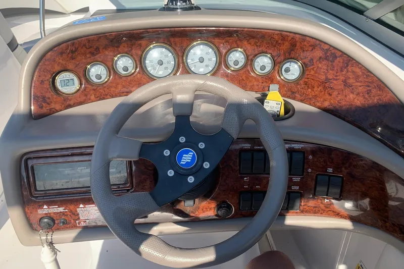 Slide: The Image of 2003 Four Winns 240 Horizon boat dashboard with wood finish and steering wheel. - 6