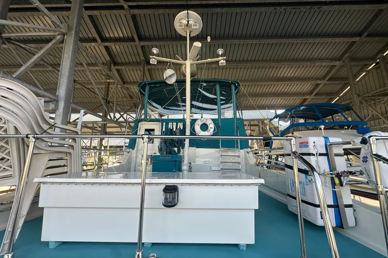 Slide: The Image of 1972 Tollycraft 42 Tri-Cabin yacht docked in a covered marina. - 12