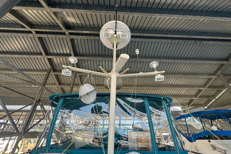 Slide: The Image of 1972 Tollycraft 42 Tri-Cabin yacht under covered dock, featuring radar and antennas. - 13