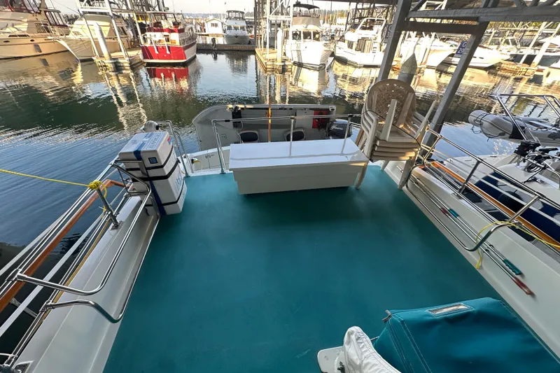 Slide: The Image of 1972 Tollycraft 42 Tri-Cabin yacht deck with marina view, featuring seating and storage. - 14