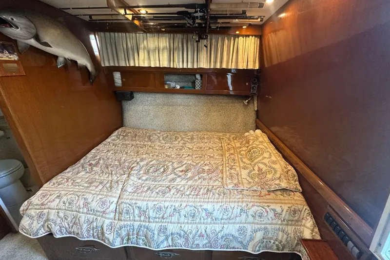 Slide: The Image of 1972 Tollycraft 42 Tri-Cabin bedroom with patterned bedding and mounted fish decor. - 30