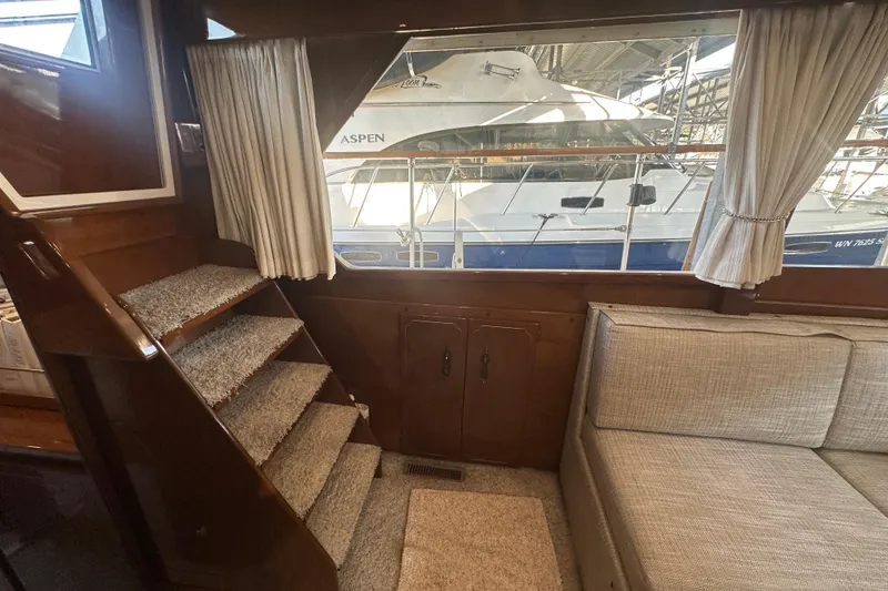 Slide: The Image of Interior of 1972 Tollycraft 42 Tri-Cabin with stairs, sofa, and window view of a boat. - 37