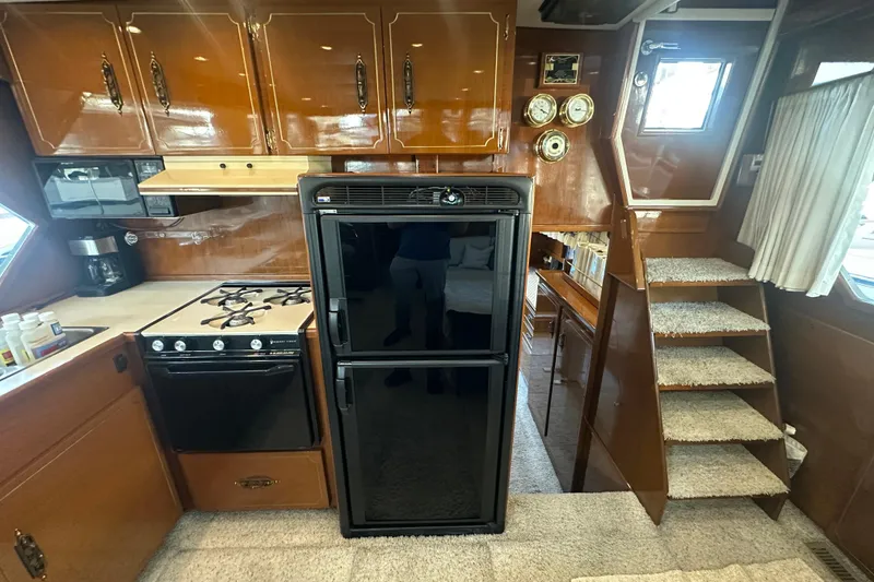 Slide: The Image of 1972 Tollycraft 42 Tri-Cabin interior with kitchen, stairs, and wooden cabinetry. - 39