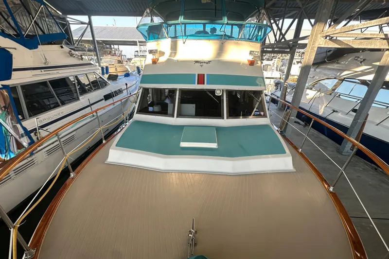 Slide: The Image of 1972 Tollycraft 42 Tri-Cabin yacht docked in a marina, surrounded by other boats. - 4