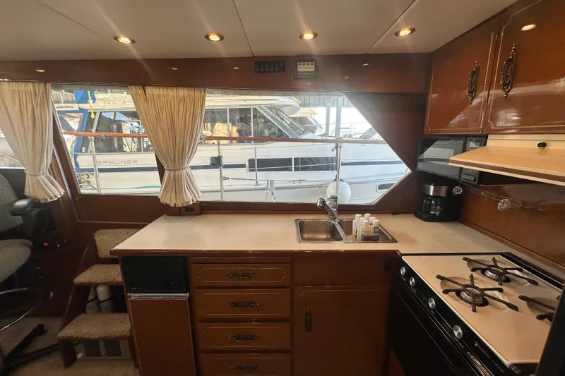 Slide: The Image of 1972 Tollycraft 42 Tri-Cabin kitchen with stove, sink, and wooden cabinetry. - 40