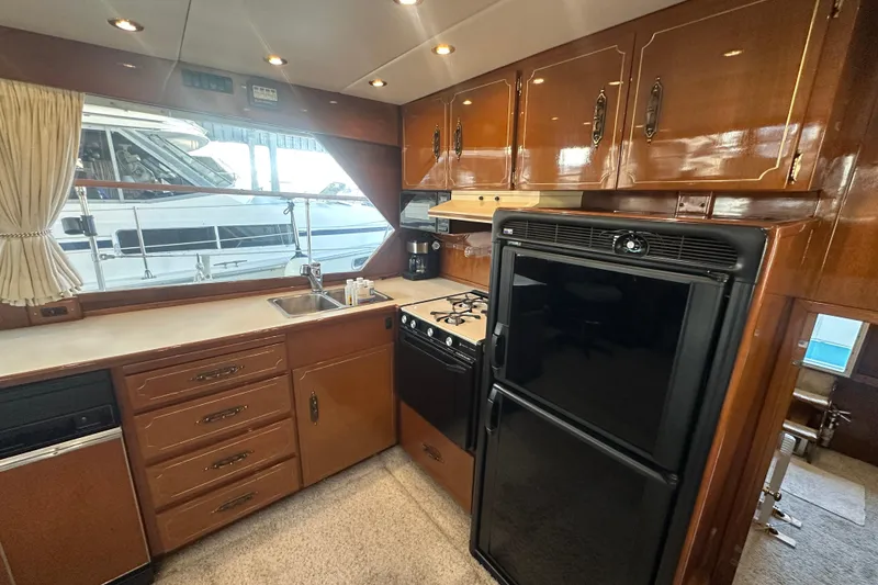 Slide: The Image of 1972 Tollycraft 42 Tri-Cabin yacht kitchen with wood cabinets and modern appliances. - 43