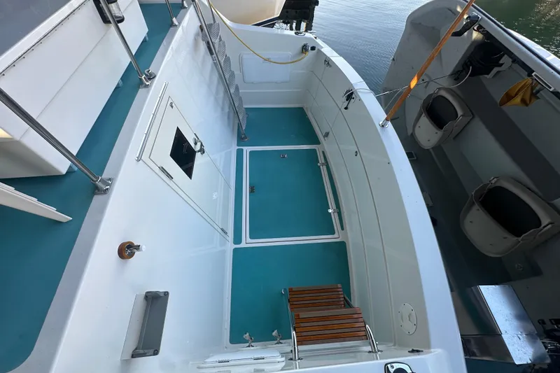 Slide: The Image of 1972 Tollycraft 42 Tri-Cabin boat deck with blue flooring and storage compartments. - 5