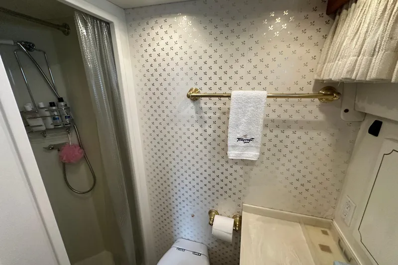 Slide: The Image of 1972 Tollycraft 42 Tri-Cabin bathroom with shower, towel rack, and patterned wallpaper. - 75