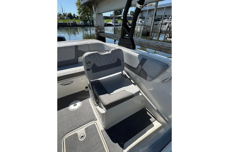 Slide: The Image of 2022 Bayliner VR6 Bowrider OB interior with gray seating and waterfront view. - 12