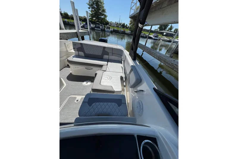 Slide: The Image of 2022 Bayliner VR6 Bowrider OB interior with gray seating, docked by the water. - 13