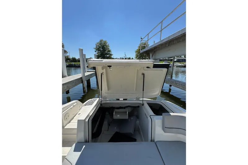 Slide: The Image of 2022 Bayliner VR6 Bowrider OB with open storage compartment at dockside. - 22