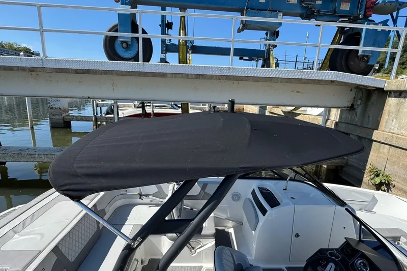 Slide: The Image of 2022 Bayliner VR6 Bowrider OB with black canopy in a marina setting. - 26